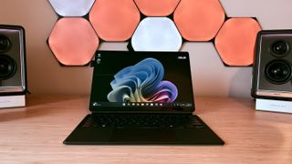 An ASUS ProArt PZ13 laptop on a wooden desk